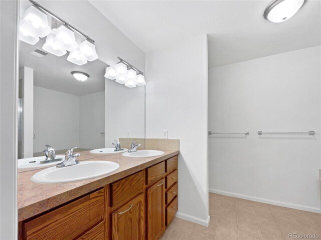 bathroom with tile patterned flooring, a sink, and baseboards