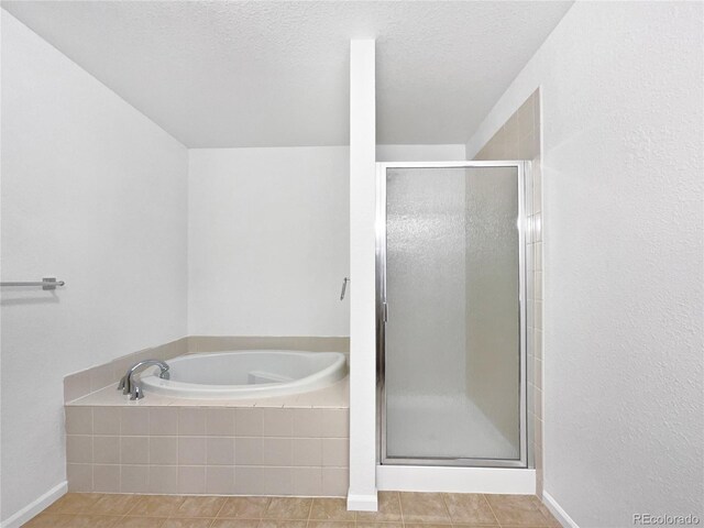 bathroom with a textured ceiling, tile patterned floors, a garden tub, and a stall shower