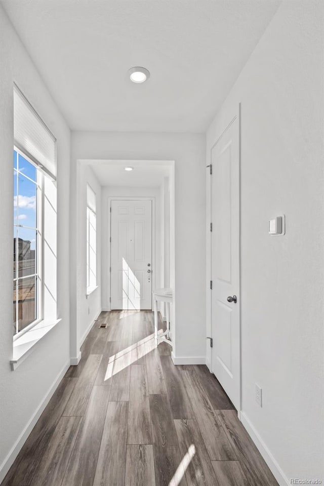 hallway featuring baseboards and wood finished floors