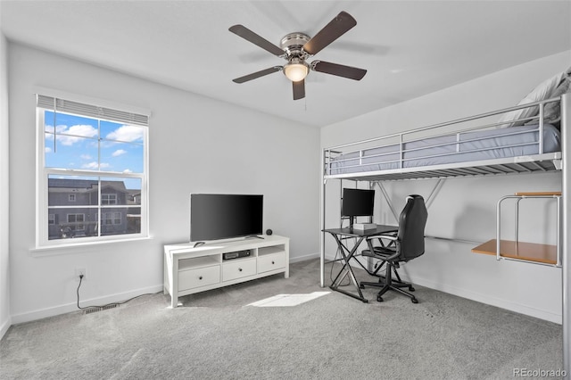 carpeted office with ceiling fan and baseboards