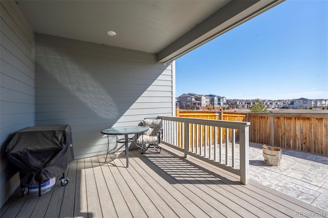 wooden terrace with a patio area, a residential view, a grill, and fence