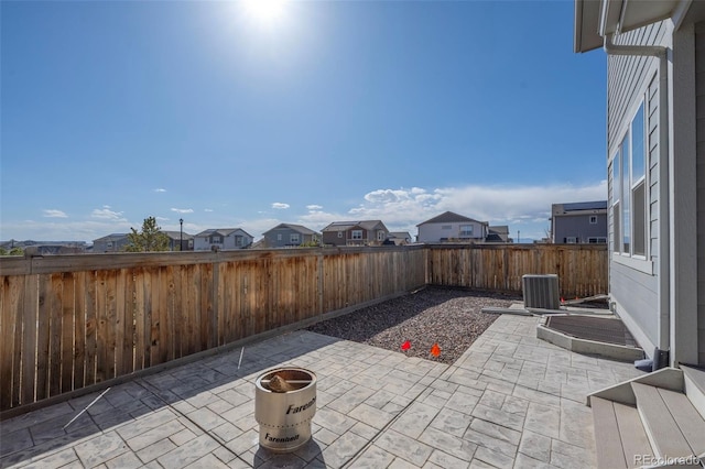 view of patio featuring cooling unit, a residential view, and a fenced backyard