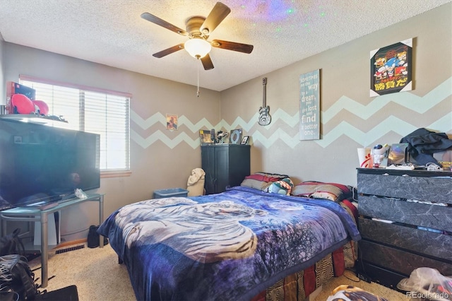 carpeted bedroom featuring a textured ceiling and ceiling fan