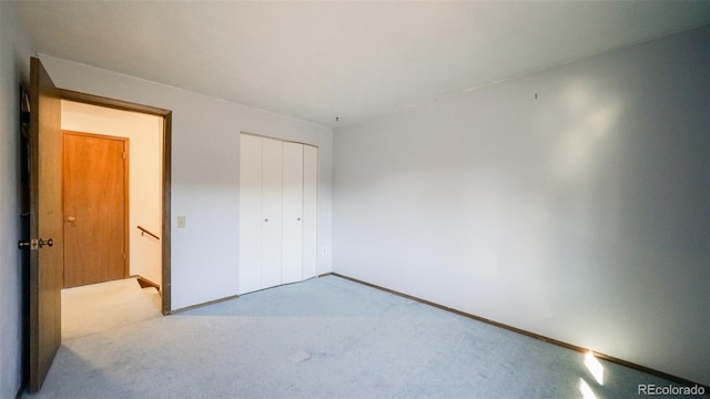 unfurnished bedroom with a closet and light carpet