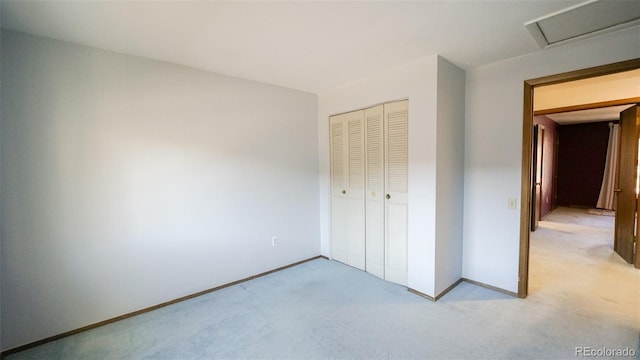 unfurnished bedroom with a closet and light colored carpet