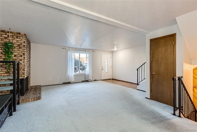 unfurnished living room with light colored carpet and a fireplace