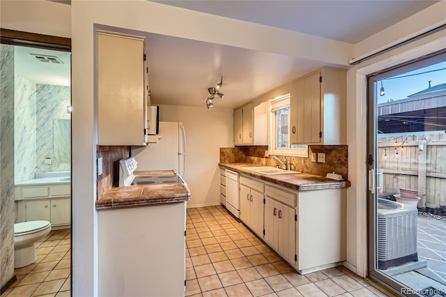 kitchen with white dishwasher, sink, white cabinets, light tile patterned floors, and stainless steel electric range