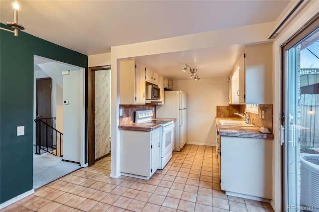 kitchen featuring sink, backsplash, white cabinets, light tile patterned flooring, and white appliances