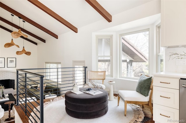 sitting room featuring vaulted ceiling with beams, a fireplace, and an upstairs landing