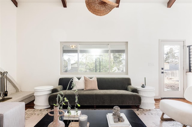 living area featuring beam ceiling and wood finished floors