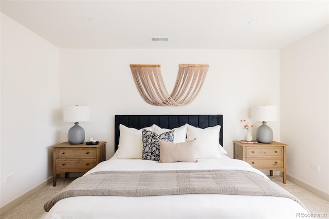 carpeted bedroom with visible vents and baseboards