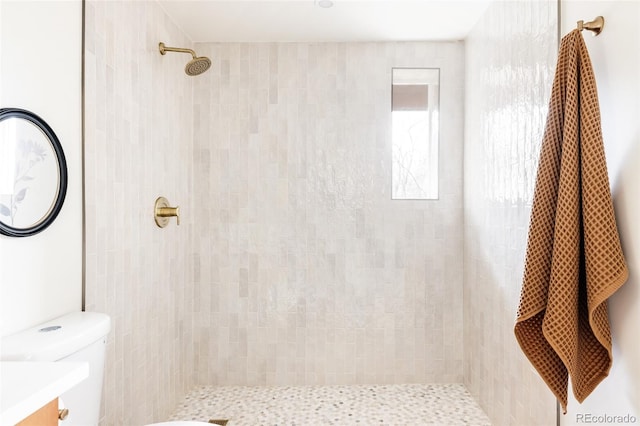 full bath featuring tiled shower, vanity, and toilet