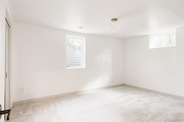 unfurnished room with carpet flooring, visible vents, and baseboards