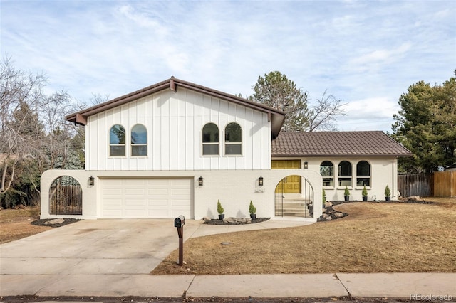 view of front of home featuring brick siding, fence, a garage, driveway, and a tiled roof