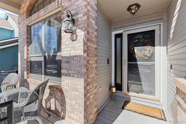 doorway to property featuring brick siding