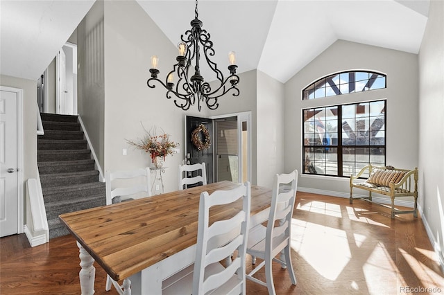 dining area featuring a chandelier, baseboards, vaulted ceiling, stairway, and dark wood-style floors