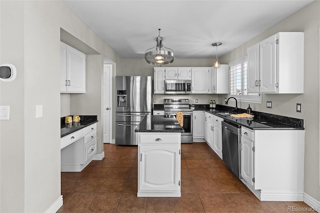 kitchen with a center island, decorative light fixtures, stainless steel appliances, white cabinets, and a sink