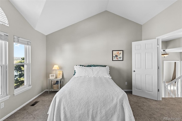 carpeted bedroom featuring visible vents, vaulted ceiling, and baseboards