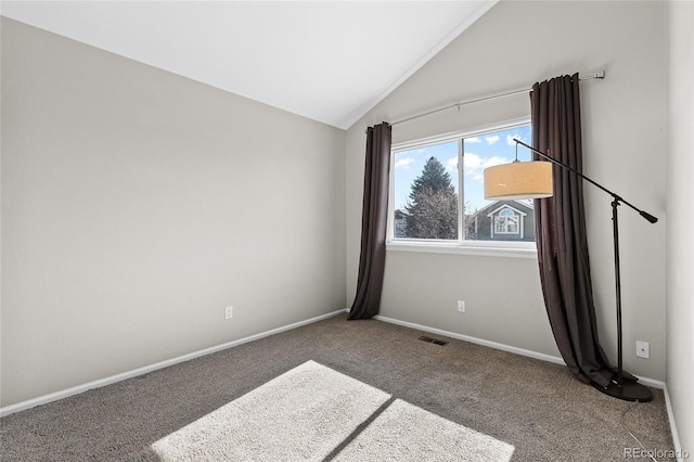 carpeted spare room featuring lofted ceiling, visible vents, and baseboards