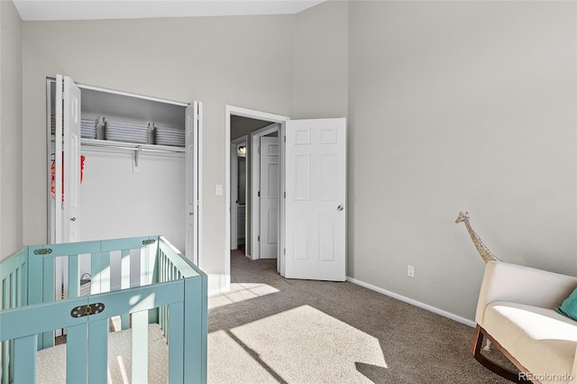 carpeted bedroom featuring baseboards and a closet