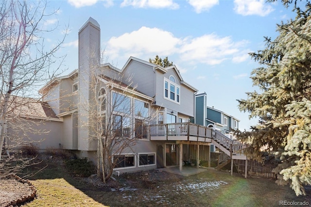 rear view of property featuring a deck, fence, stairway, a chimney, and a patio area