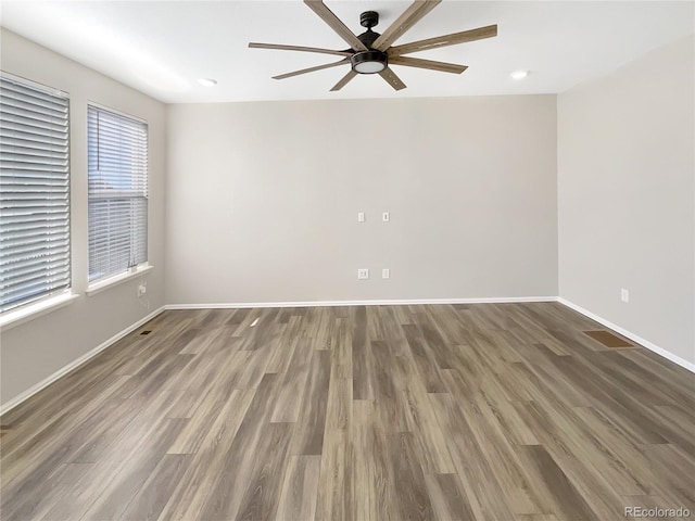 unfurnished room with ceiling fan and dark hardwood / wood-style flooring