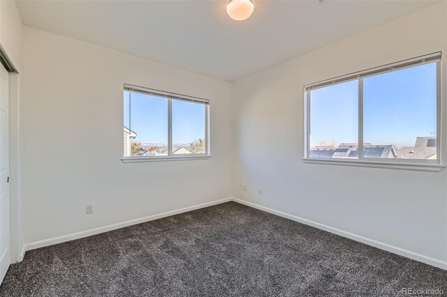 carpeted spare room featuring a wealth of natural light