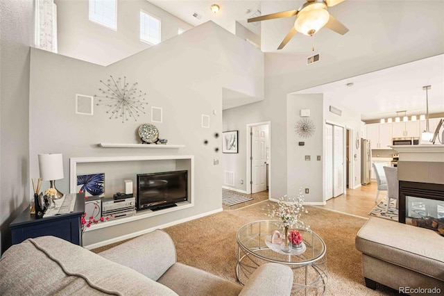 2476 S Gibralter Way, Aurora, CO 80013 - living room featuring a towering ceiling, ceiling fan, and light carpet