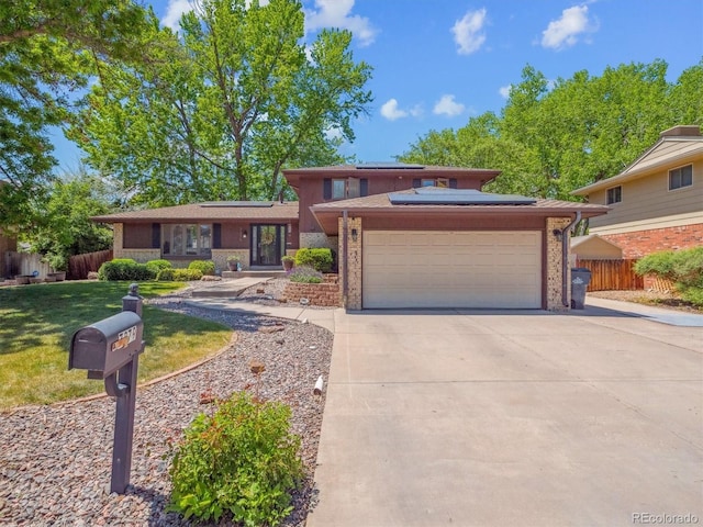 7379 S Lafayette Cir W, Centennial, CO 80122 - view of front facade with a garage, concrete driveway, solar panels, and brick siding