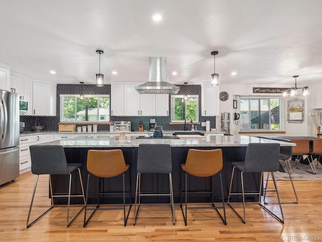 7379 S Lafayette Cir W, Centennial, CO 80122 - kitchen with stainless steel appliances, island range hood, tasteful backsplash, a large island, and recessed lighting