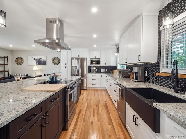 7379 S Lafayette Cir W, Centennial, CO 80122 - kitchen with island range hood, stainless steel appliances, a sink, white cabinets, and recessed lighting