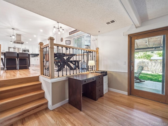 7379 S Lafayette Cir W, Centennial, CO 80122 - staircase with a chandelier, a textured ceiling, wood finished floors, wainscoting, and baseboards