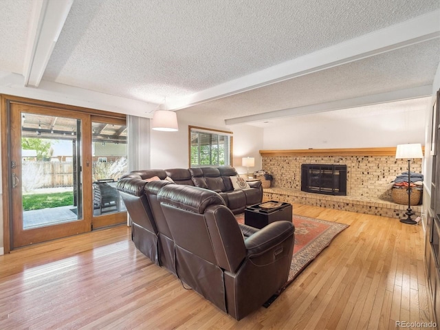 7379 S Lafayette Cir W, Centennial, CO 80122 - living area with beam ceiling, a textured ceiling, light wood-type flooring, and a fireplace