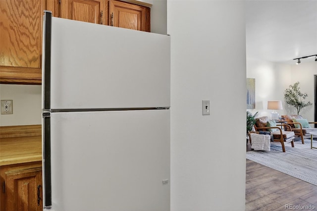 31270 John Wallace Rd Unit 302, Evergreen, CO 80439 - kitchen featuring freestanding refrigerator, brown cabinetry, wood finished floors, and track lighting