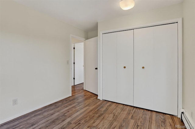 31270 John Wallace Rd Unit 302, Evergreen, CO 80439 - unfurnished bedroom with baseboard heating, wood finished floors, and a closet