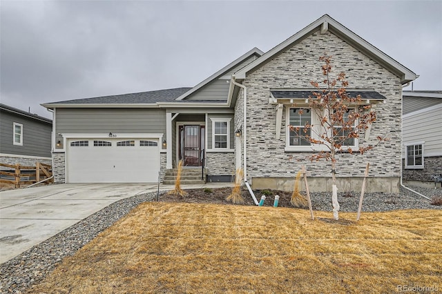 view of front of home with stone siding, an attached garage, and concrete driveway