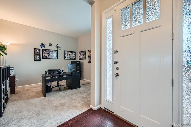 entryway featuring baseboards and dark colored carpet