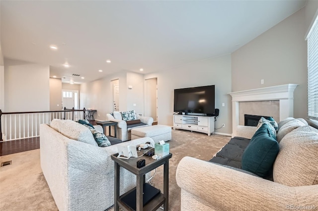 carpeted living area with recessed lighting, visible vents, and a fireplace