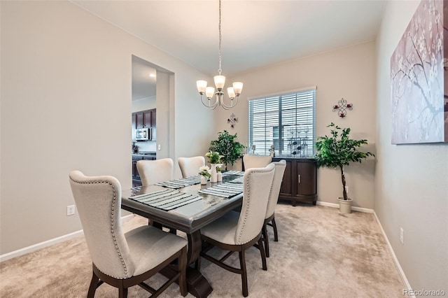 dining space featuring a notable chandelier, baseboards, and light colored carpet