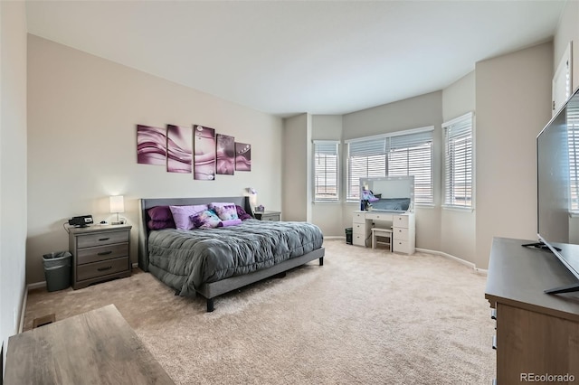 bedroom featuring light colored carpet and baseboards