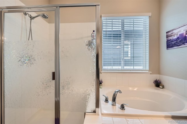 full bathroom with a garden tub, a healthy amount of sunlight, and a shower stall