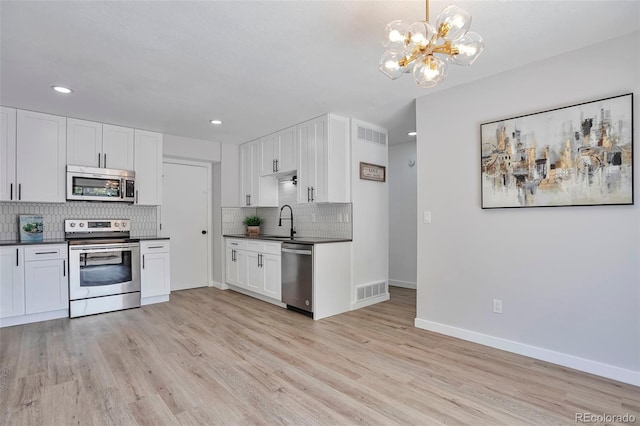 3575 S Ouray St, Aurora, CO 80013 - kitchen featuring stainless steel appliances, a chandelier, dark countertops, a sink, and backsplash