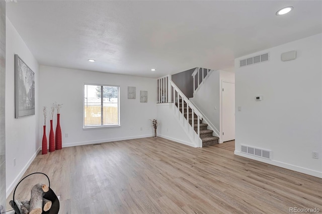 3575 S Ouray St, Aurora, CO 80013 - unfurnished living room featuring light wood-style floors, stairway, baseboards, and recessed lighting