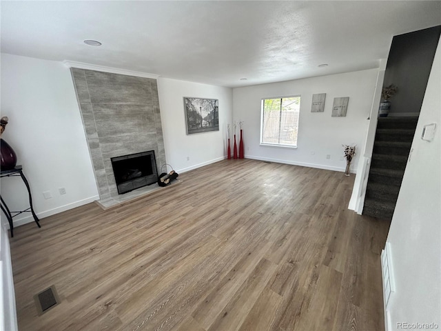 3575 S Ouray St, Aurora, CO 80013 - unfurnished living room with stairway, a tiled fireplace, wood finished floors, and baseboards
