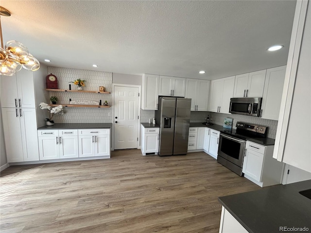 3575 S Ouray St, Aurora, CO 80013 - kitchen featuring stainless steel appliances, dark countertops, white cabinetry, recessed lighting, and decorative backsplash