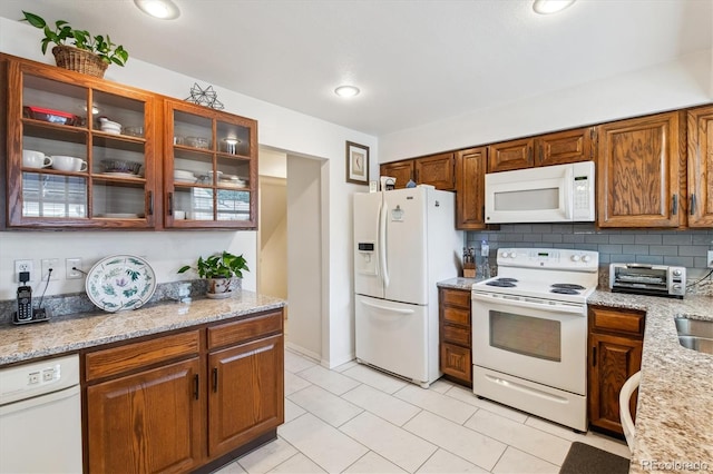 2437 E Geddes Pl, Centennial, CO 80122 - kitchen featuring white appliances, glass insert cabinets, light tile patterned flooring, and light stone countertops