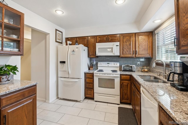 2437 E Geddes Pl, Centennial, CO 80122 - kitchen featuring white appliances, a sink, light stone countertops, light tile patterned flooring, and glass insert cabinets