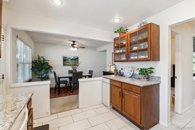 2437 E Geddes Pl, Centennial, CO 80122 - kitchen with light tile patterned flooring, glass insert cabinets, ceiling fan, brown cabinets, and recessed lighting