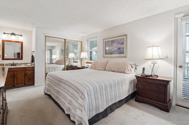 2437 E Geddes Pl, Centennial, CO 80122 - bedroom with light colored carpet, a textured ceiling, a closet, and ensuite bathroom