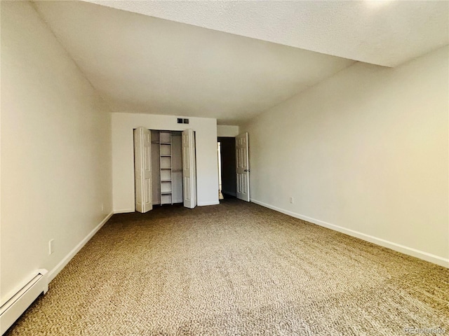 unfurnished bedroom featuring lofted ceiling, carpet floors, and a baseboard heating unit